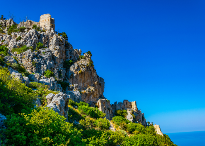 Ruinen von St. Hilarion Castle, thront majestätisch auf einem steilen Felsvorsprung unter strahlend blauem Himmel in Nordzypern.