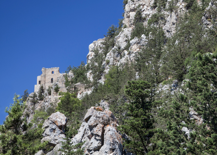 Blick von oben auf die zerklüfteten Ruinen von Buffavento Castle, gelegen auf einem felsigen Gipfel in Nordzypern mit Blick auf das Meer.