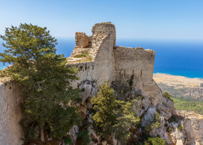 Blick von der Seite auf die zerklüfteten Ruinen von Kantara Castle, gelegen auf einem felsigen Gipfel in Nordzypern mit Blick auf das Meer.